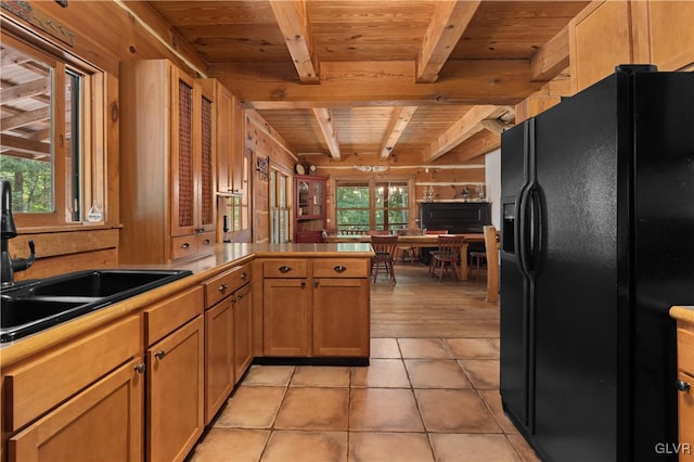 kitchen with light tile patterned floors, sink, black refrigerator with ice dispenser, and wooden ceiling