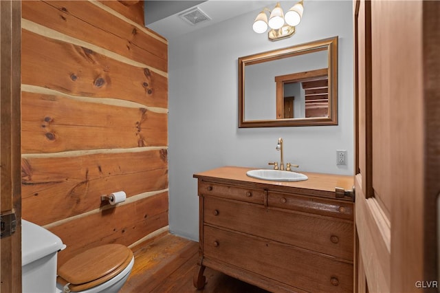 bathroom with vanity, toilet, and hardwood / wood-style flooring