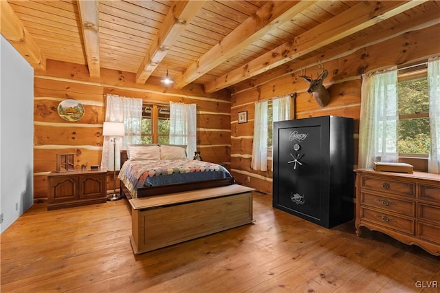 bedroom with wooden walls, beam ceiling, light hardwood / wood-style floors, and wood ceiling