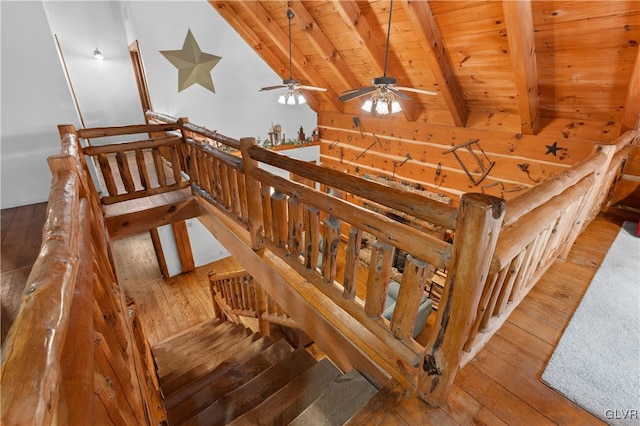 stairs featuring beam ceiling, hardwood / wood-style floors, and wooden ceiling