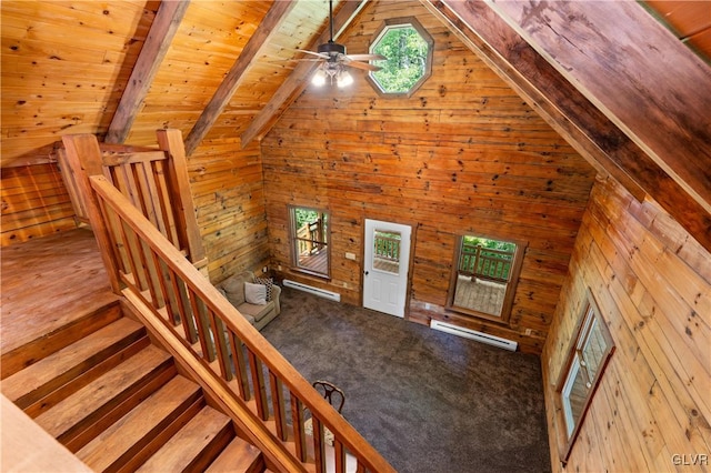 stairs featuring lofted ceiling with beams, wood walls, wooden ceiling, and carpet