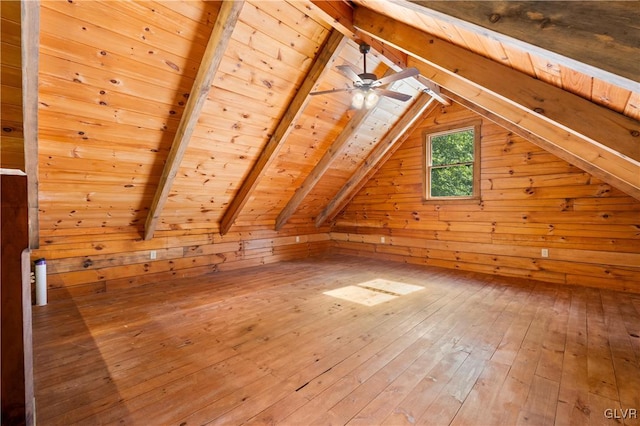 bonus room with wood-type flooring, wooden walls, lofted ceiling with beams, and wooden ceiling