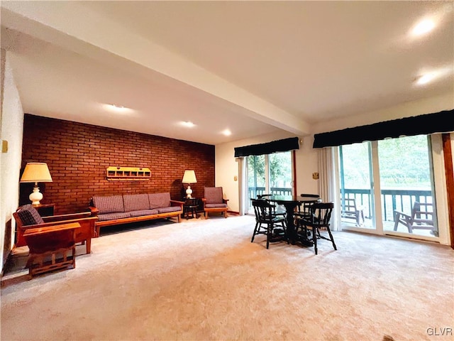 carpeted dining room featuring beamed ceiling and brick wall