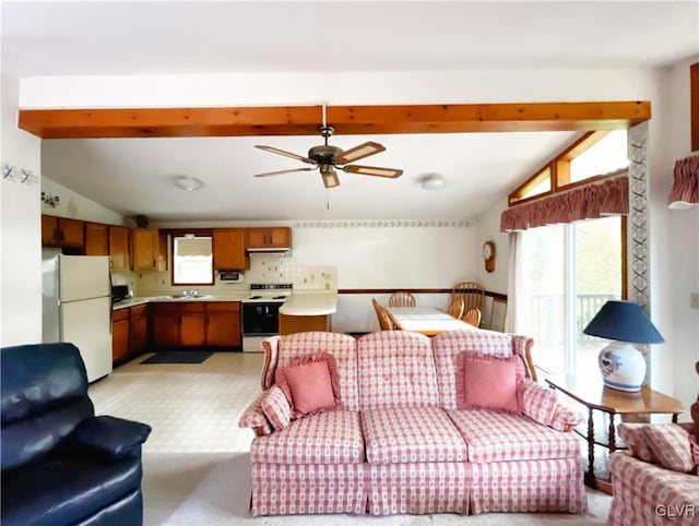 living room featuring ceiling fan, vaulted ceiling with beams, and sink