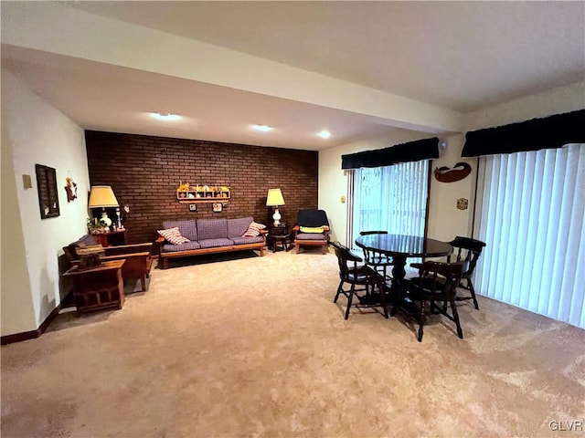 dining room featuring carpet and brick wall