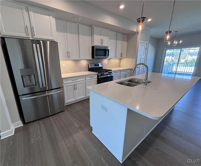 kitchen featuring appliances with stainless steel finishes, dark wood-type flooring, sink, and white cabinets