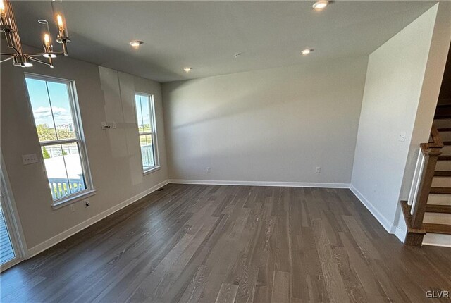 unfurnished dining area featuring dark wood-type flooring and a chandelier