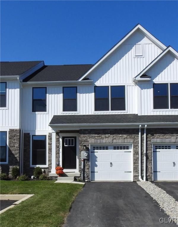 multi unit property featuring a front yard and a garage