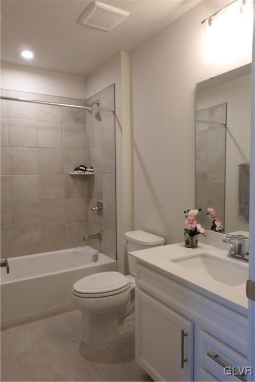 full bathroom featuring toilet, tile patterned flooring, vanity, and tiled shower / bath