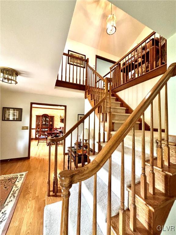 stairway with lofted ceiling and hardwood / wood-style flooring