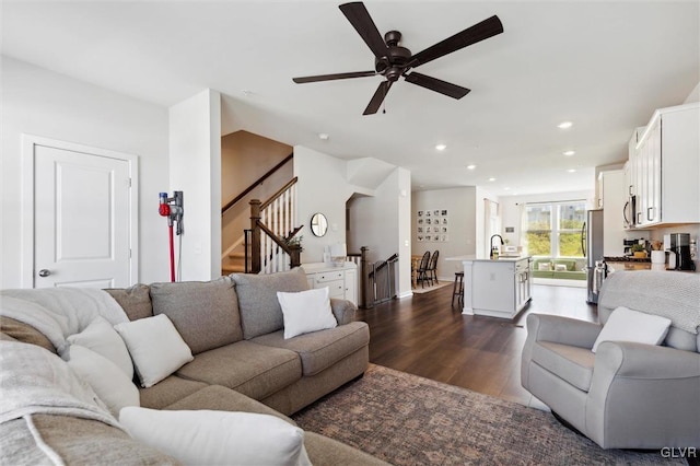 living room with dark hardwood / wood-style flooring, ceiling fan, and sink