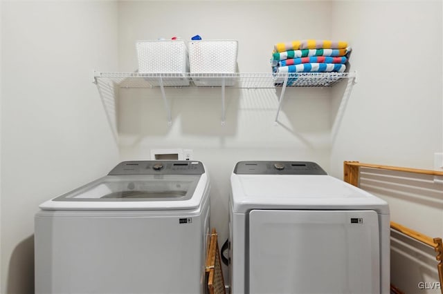 clothes washing area featuring washer and clothes dryer