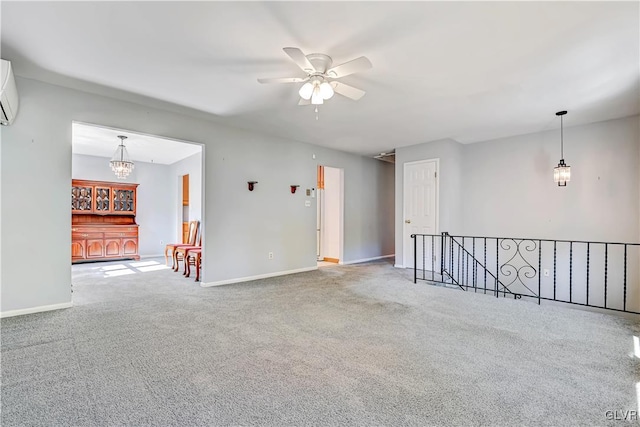 unfurnished room featuring a wall mounted air conditioner, carpet, and ceiling fan with notable chandelier