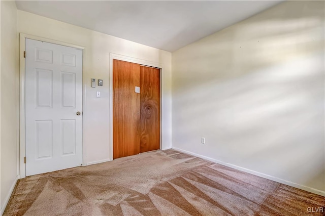 unfurnished bedroom featuring carpet flooring and a closet