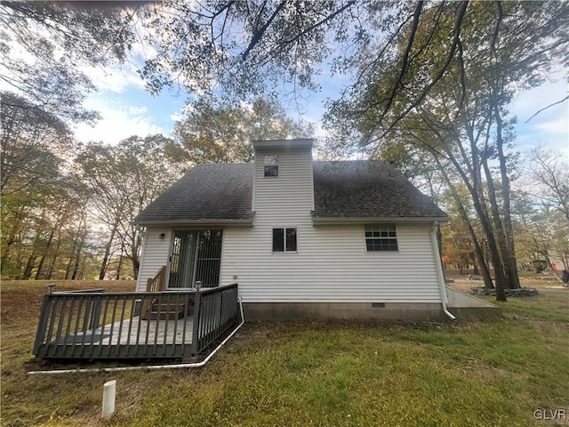 back of property with a wooden deck and a lawn