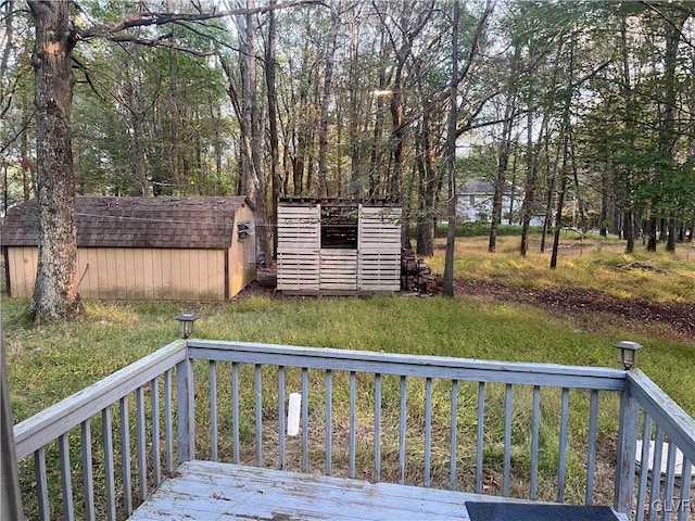 deck featuring a storage shed, a lawn, and a water view