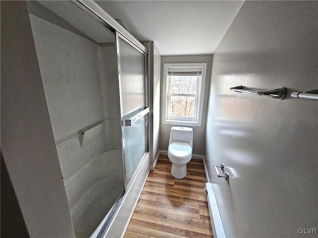 bathroom featuring hardwood / wood-style floors, an enclosed shower, and toilet