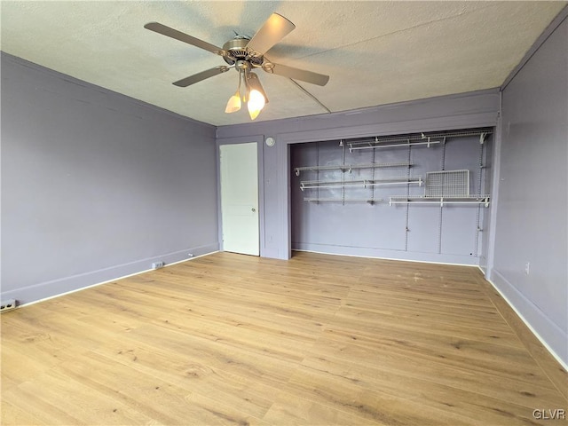 unfurnished bedroom featuring a closet, a textured ceiling, light wood-type flooring, and ceiling fan