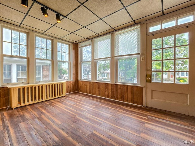 unfurnished sunroom featuring radiator heating unit, track lighting, and a paneled ceiling