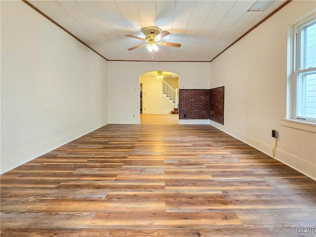 spare room with ornamental molding, light wood-type flooring, and ceiling fan