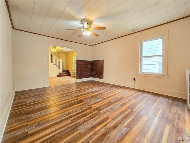 empty room featuring ornamental molding, hardwood / wood-style flooring, and ceiling fan