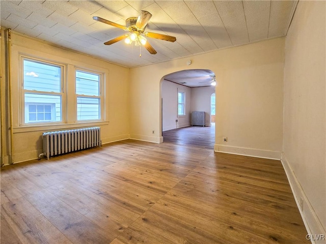 unfurnished room featuring ornamental molding, hardwood / wood-style floors, radiator, and ceiling fan