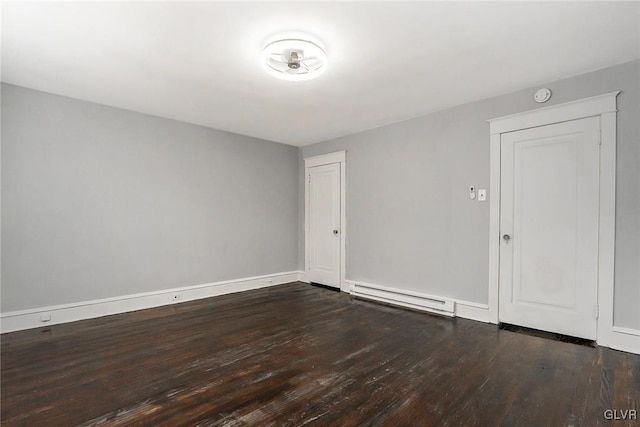 unfurnished room featuring a baseboard radiator and dark hardwood / wood-style floors