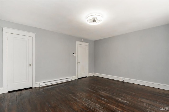 unfurnished room featuring a baseboard heating unit and hardwood / wood-style floors