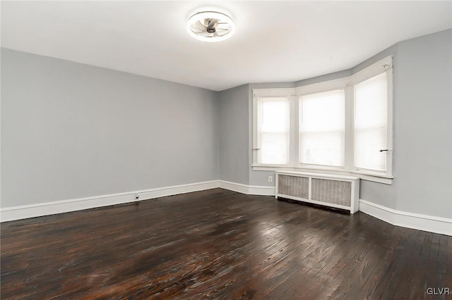 unfurnished room featuring radiator and hardwood / wood-style floors