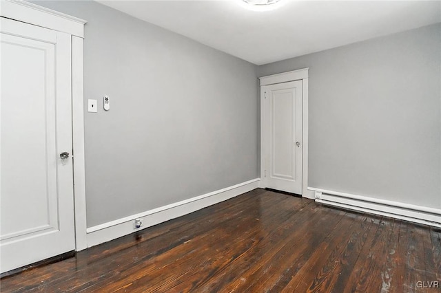 unfurnished room with wood-type flooring and a baseboard heating unit