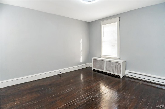 unfurnished room featuring a baseboard heating unit, radiator heating unit, and hardwood / wood-style flooring