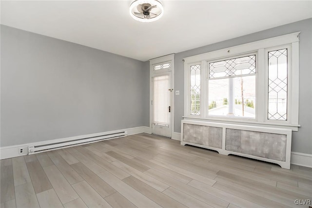 foyer entrance with a baseboard heating unit, light hardwood / wood-style floors, and radiator