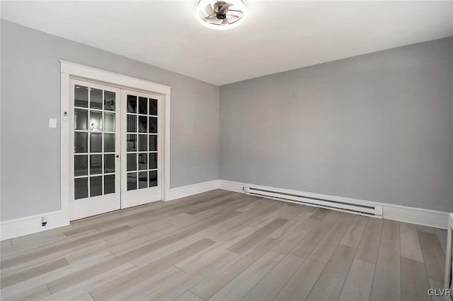 empty room featuring light wood-type flooring, french doors, and baseboard heating