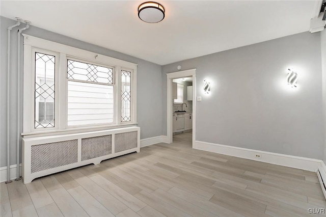 foyer featuring radiator heating unit, light hardwood / wood-style flooring, and sink