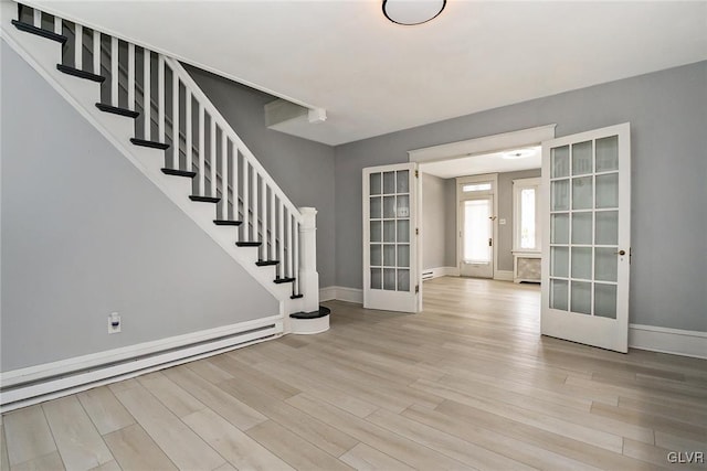 foyer with a baseboard heating unit, french doors, and light hardwood / wood-style flooring