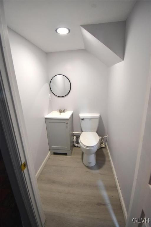 bathroom with vanity, toilet, and hardwood / wood-style flooring