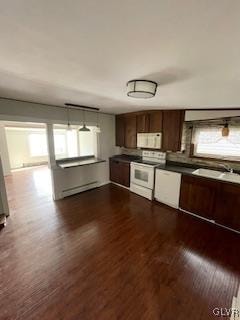 kitchen featuring dark hardwood / wood-style flooring, baseboard heating, and white appliances