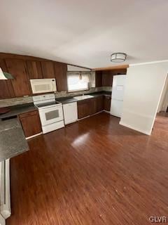 kitchen featuring white appliances, dark wood-type flooring, and wooden walls