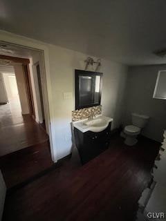 bathroom with vanity, toilet, and hardwood / wood-style floors