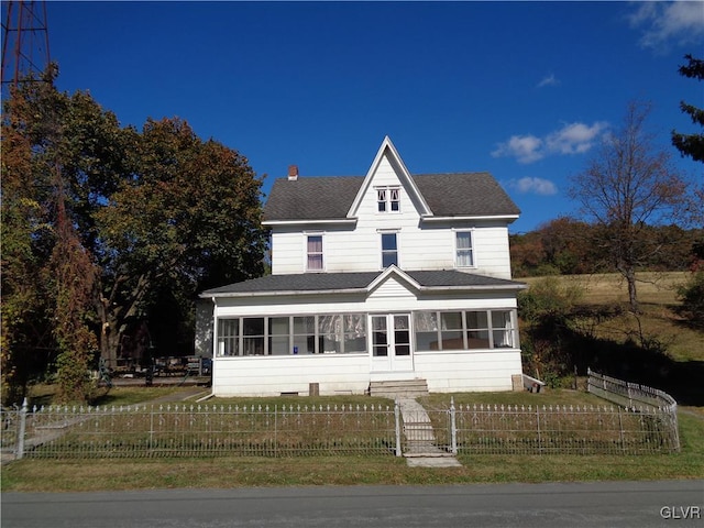 view of front of property featuring a front yard and a sunroom