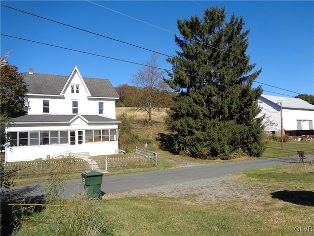 view of front of house featuring a front lawn and a sunroom