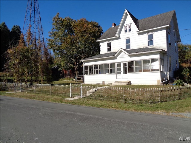 view of front of property with a front lawn and a sunroom