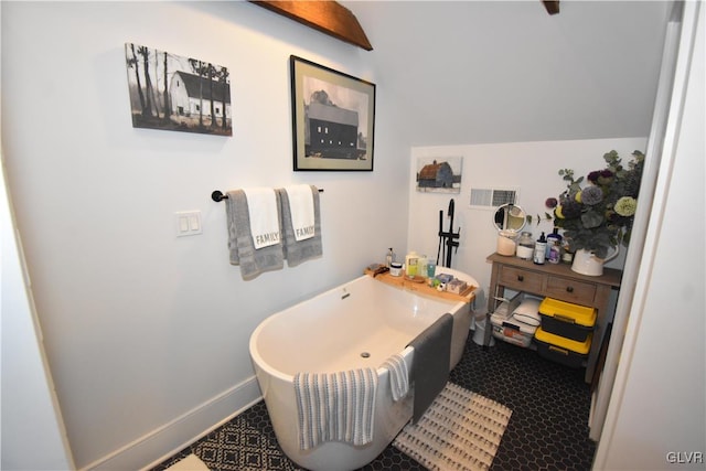 bathroom featuring lofted ceiling and a bath