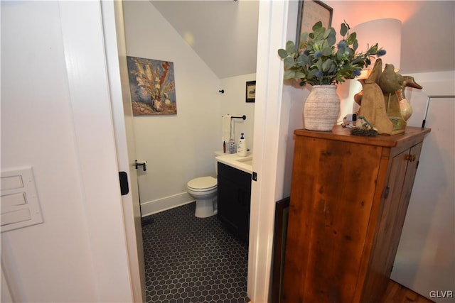 bathroom with vanity, lofted ceiling, and toilet