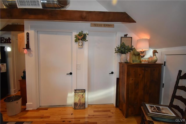 interior space featuring lofted ceiling and light hardwood / wood-style floors