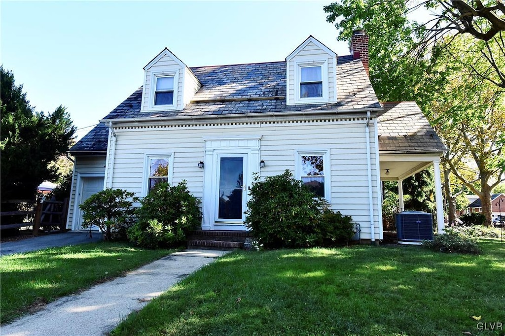 new england style home with cooling unit and a front lawn