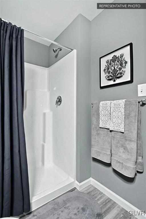 bathroom with hardwood / wood-style flooring and walk in shower