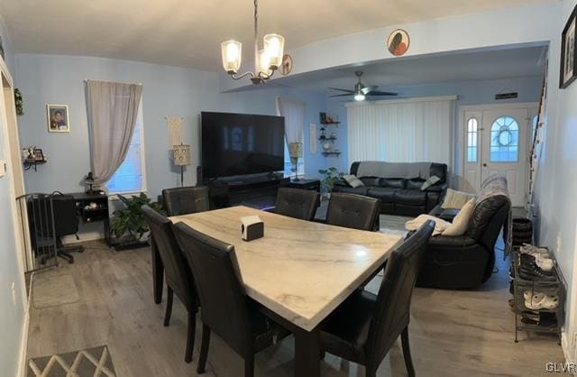 dining room featuring hardwood / wood-style flooring and ceiling fan with notable chandelier