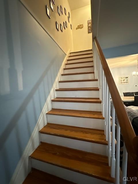 staircase with a notable chandelier