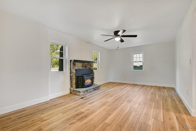 3331 Walnut St, Bethlehem Twp, PA 18020 - unfurnished living room featuring light wood finished floors, baseboards, ceiling fan, and a wood stove